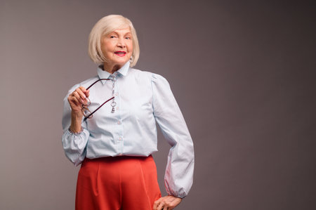 Stylish senior woman in white blouse looking confidentの写真素材