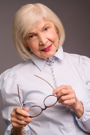 Stylish senior woman in white blouse looking confidentの写真素材