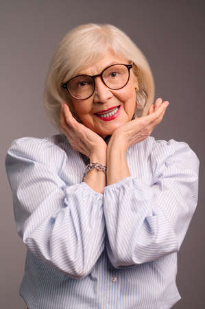 Blonde senior woman in eyeglasses looking cuteの写真素材