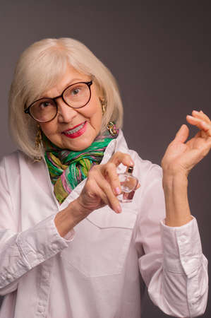 Pretty senior woman trying a new fragrance and looking interestedの写真素材