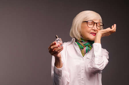 Pretty senior woman trying a new fragrance and looking interestedの写真素材