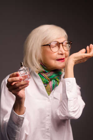 Pretty senior woman trying a new fragrance and looking interestedの写真素材