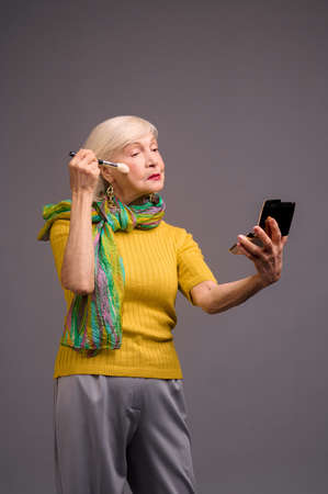 Short-haired blonde senior woman doing make-ipの写真素材