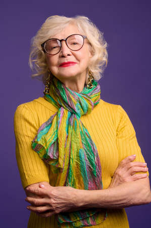 Pretty senior woman in eyeglasses looking confident and positiveの写真素材