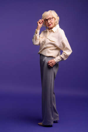 Slim and pretty blonde senior woman in stylish clothesの写真素材