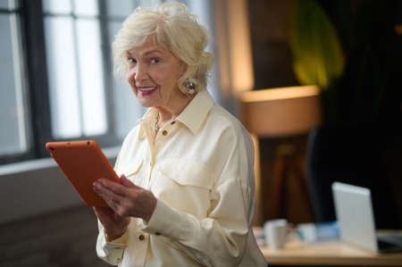 Woman holding tablet looking at cameraの写真素材
