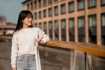 Girl standing near railing looking to sideの写真素材