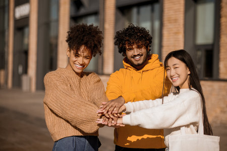 Two girls and guy touching outstretched handsの写真素材
