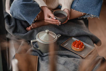 Close up picture of a girl having tea while sitting on the floorの写真素材
