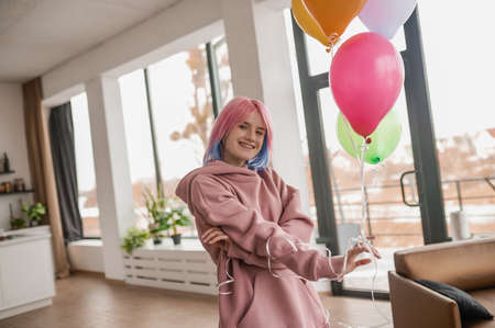 Cute young girl with colored hair looking happyの写真素材