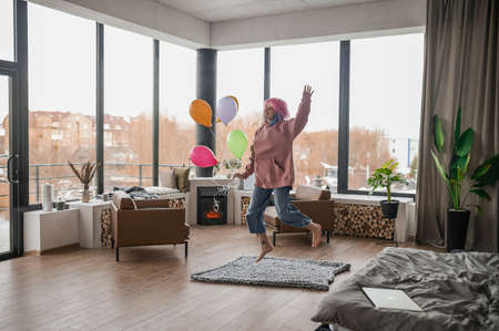 A happy smiling young girl with a bunch of balloonsの写真素材