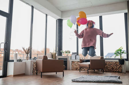 A happy smiling young girl with a bunch of balloonsの写真素材