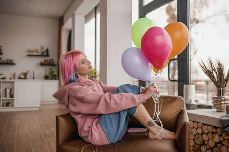 A girl with bright balloons feeling happy and joyfulの写真素材