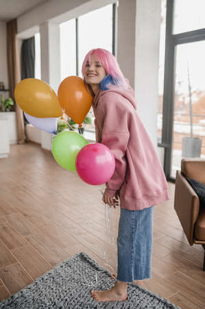 A girl with bright balloons feeling happy and joyfulの写真素材