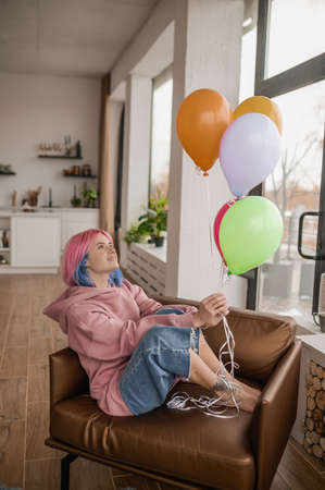 A cute girl with balloons spendng a ay in a fancy moodの写真素材