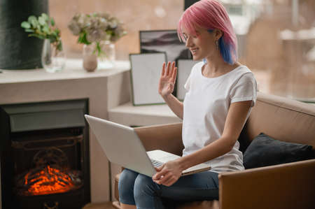 A girl with pink hair having a video callの写真素材