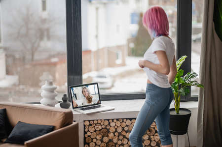 A girl with pink hair having a video callの写真素材