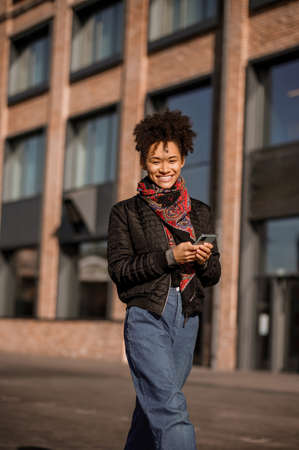 Dark-haired young girl in jacket and jeans in the streetの写真素材