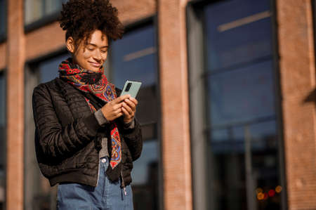 Dark-haired young girl in jacket and jeans in the streetの写真素材