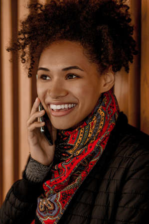 A pretty dark-skinned girl with a phoneの写真素材