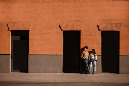 Two girls standing at the brick wallの写真素材