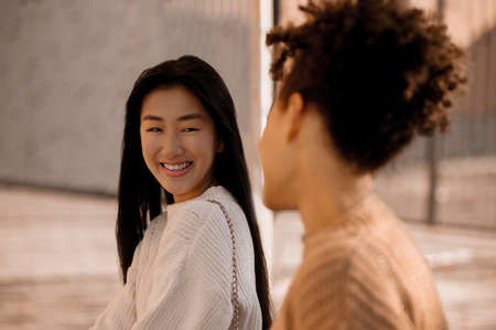 Two cute young girls talking and looking at each otherの写真素材