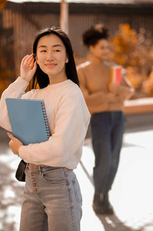A cute long-haired asian girl with a bookの写真素材