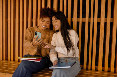 Girls watching something on internet and looking interestedの写真素材