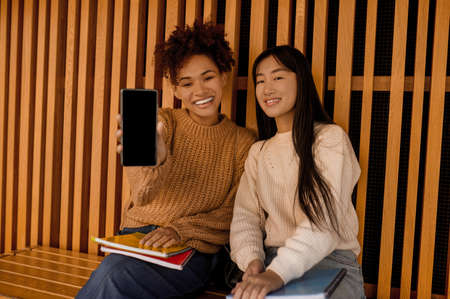 Two young girls sitting close and feeling goodの写真素材