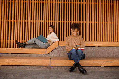 Two girls sitting in pavillion and studyingの写真素材