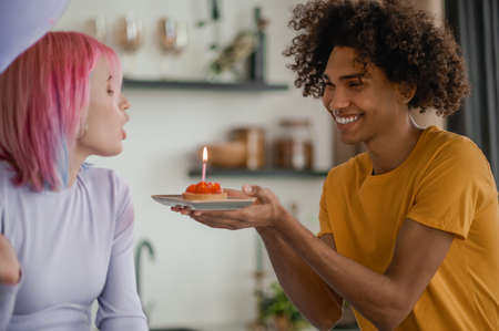 Curly-haired young man congratulating his girlfriend with valentines dayの写真素材