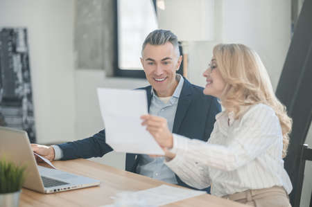 Two business partners discussing new offer and looking involvedの写真素材