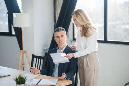 Blonde woman showing na document to her bossの写真素材