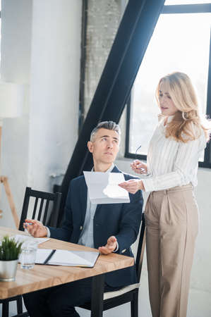 Blonde woman showing na document to her bossの写真素材