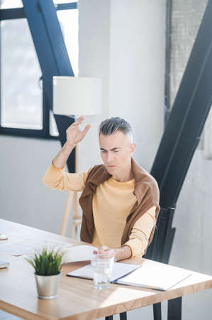 A man in the office looking involved while scrutinizing the documentsの写真素材