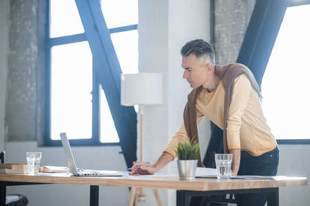 A man in the office looking involved while scrutinizing the documentsの写真素材