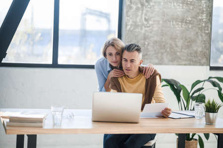 A couple in the office looking interetsed while reading newsの写真素材