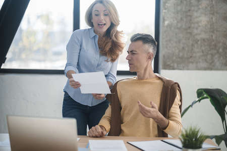 A man and a woman in the office talking and discussing a projectの写真素材
