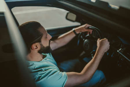 Young handsome dark-haired man driving a carの写真素材