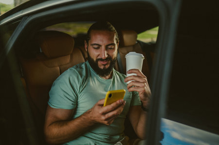 A young with a coffee cup sitting in a carの写真素材