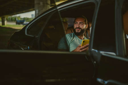 A young with a coffee cup sitting in a carの写真素材