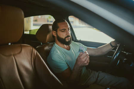A young vearded driver in a car with a female clientの写真素材