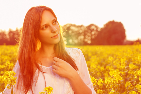 Young caucasian woman is posing in the field of rapeの写真素材