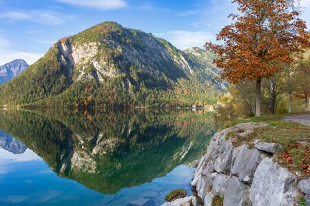 Mountains are reflected in the water of a mountain lake. The picture is taken in Alps at Plansee in Tirolの写真素材