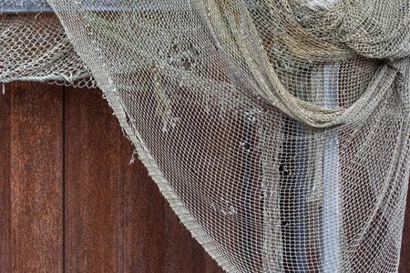 Drying old holey fishing net. Maritime nautical background texture.の写真素材