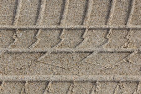Tire trail print on sand. Trail mark on a beach. Tyre protector trail closeup backgroundの写真素材