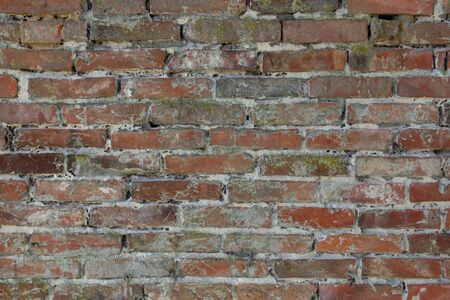 Old brick wall with cracks and scratches. Horizontal wide brickwall background.の写真素材