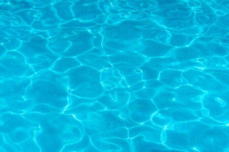 Water surface with light reflections in a swimming pool as a backgroun or textureの写真素材