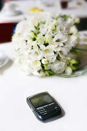 Wedding bouquet with the phone lying on the banquet table 