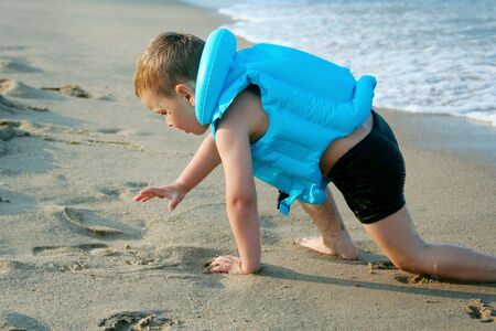 The boy crawls ashore from the sea, very utavshy, but very happy の写真素材